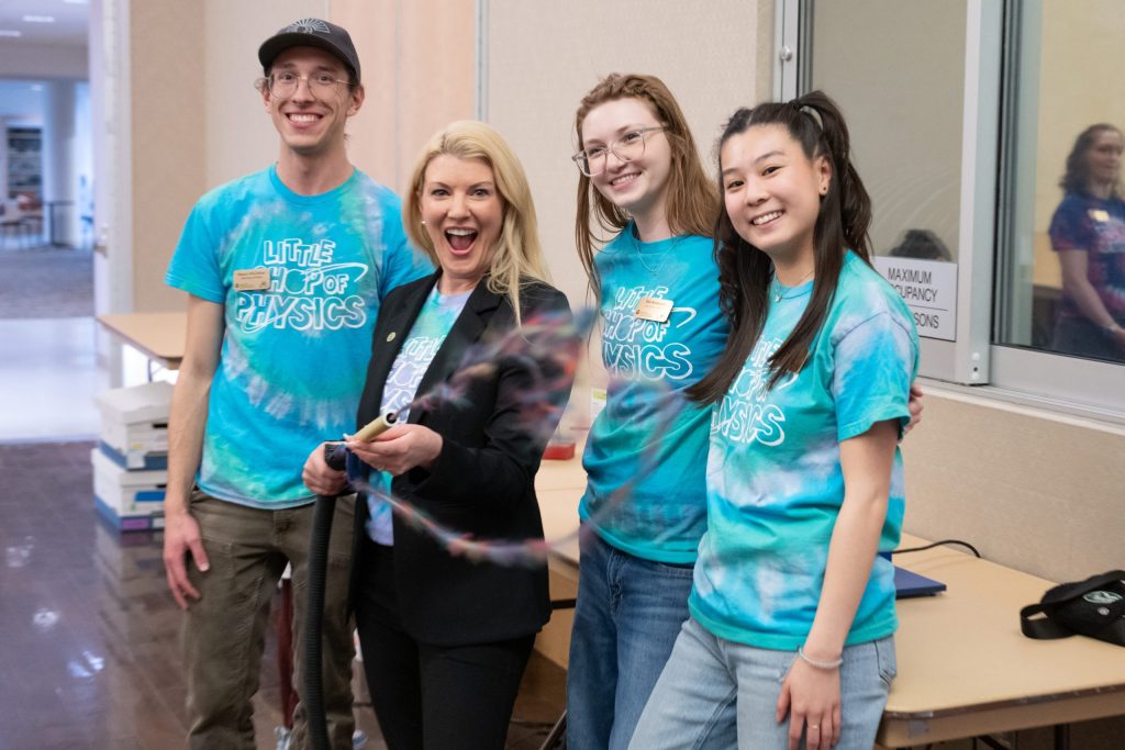 President Parsons holding a tube with string and 3 LSOP interns